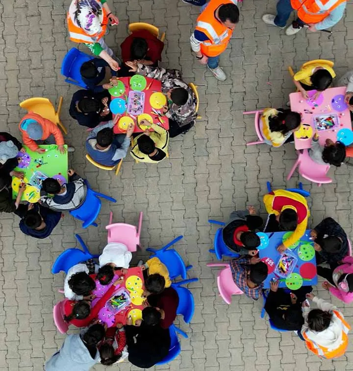 groupes d'enfants autour de tables, vus d'en haut