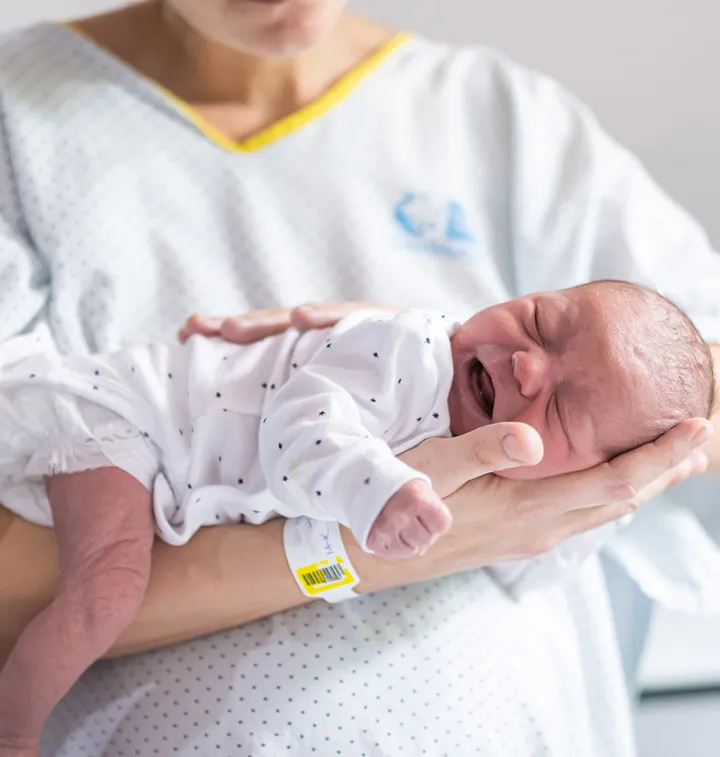 nouveau-né posé sur le bras de sa maman