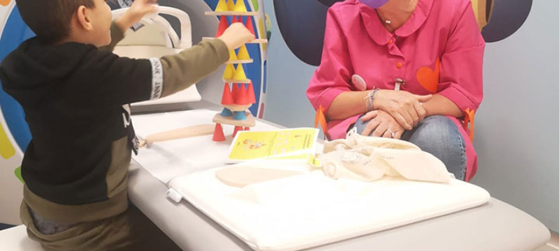 Enfant jouant avec une bénévole des Blouses Roses